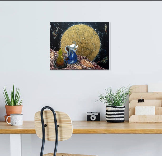 Blue black and gold spiritual artwork hanging on a white wall above a wooden desk.