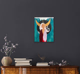 red, white, blue, gold and silver divine feminine artwork hanging on a large, dark grey wall above a wood and golden cabinet with books, decorative flowers and a bird on it
