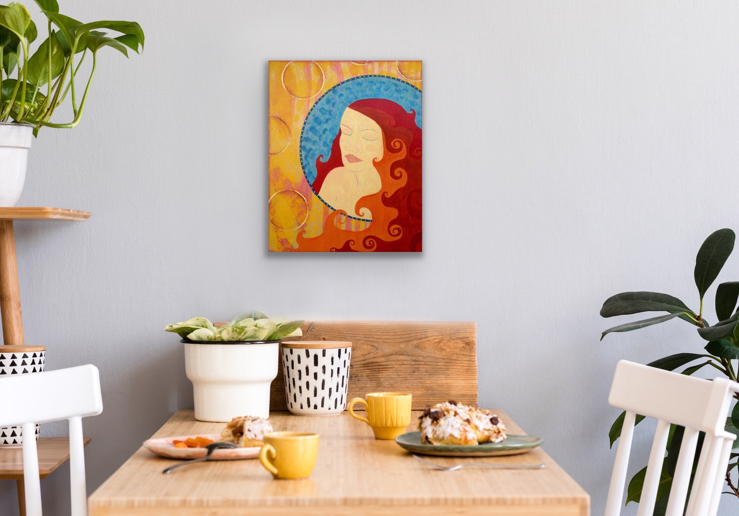 vibrant red orange yellow and blue feminine artwork hanging in a kitchen nook