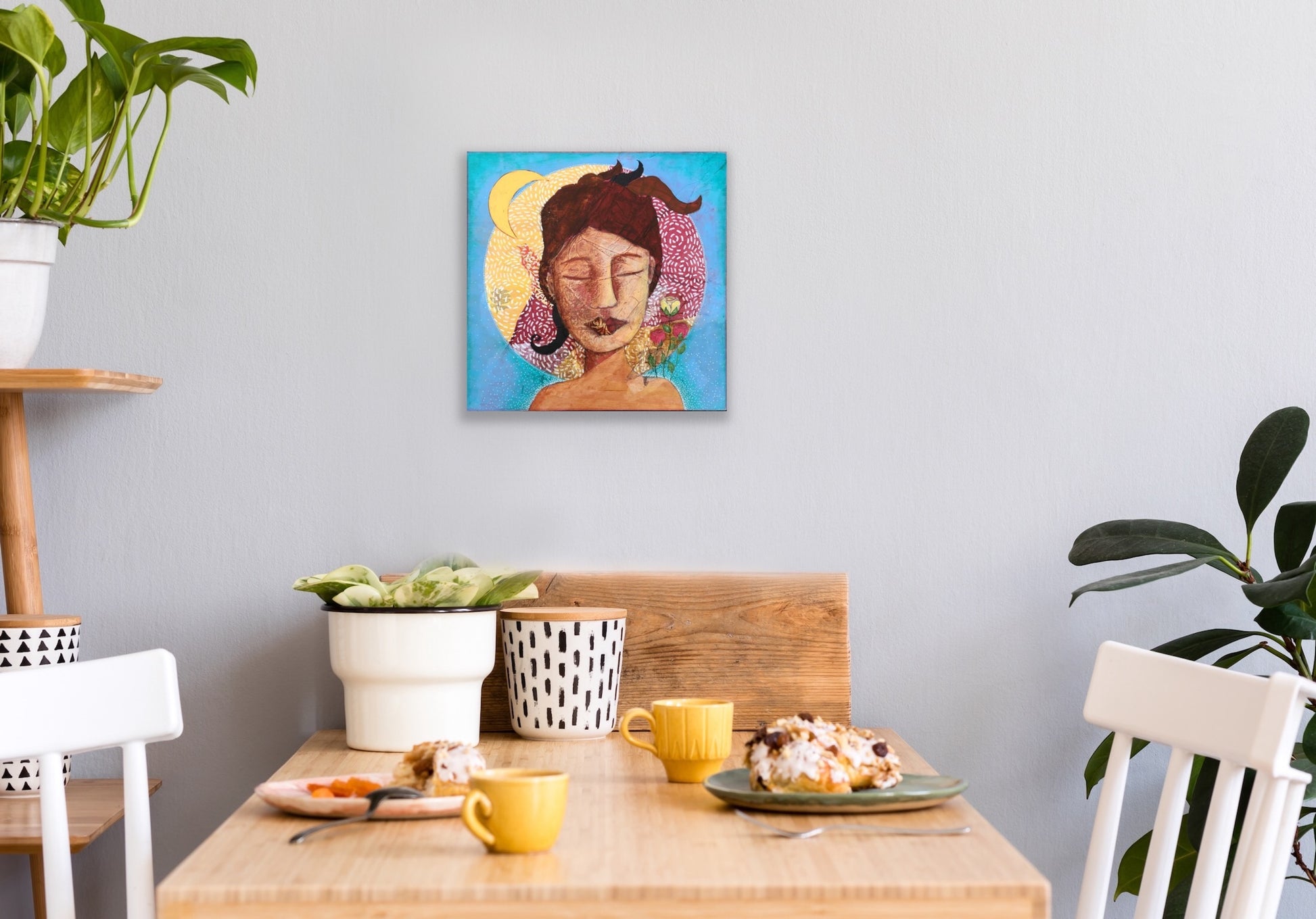divine feminine artwork hanging on a wall above a dining room table